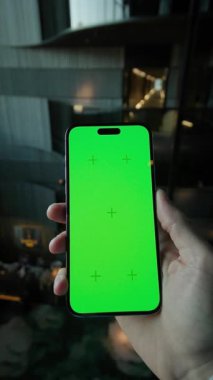El ele tutuşan adamı kapatın ve yeşil ekranlı dikey olarak telefonu kaydırın. İçerideki kafede akıllı telefondan yazılıyor.