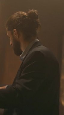 Ciddi bir iş adamının portresi masaya oturup kağıtlarla çalışmak. Gece ofisindeki bilgisayarı kullan. İşine odaklan. Akşam ışığı