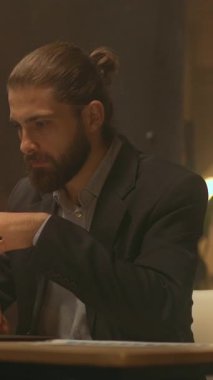 Çekici bir iş adamının portresi masaya oturup çalışıyor. Gece ofisindeki bilgisayarı kullan. İşine odaklan. Akşam ışığı