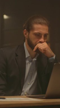 Çekici bir iş adamının portresi masa başında çalışıyor. Gece ofisindeki bilgisayarı kullan. İşine odaklan. Akşam ışığı