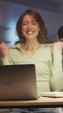 Kamera, dizüstü bilgisayarın başında oturan ve klavyede yazan kadın serbest yazar. Başarılı bir projeyi kutlayan mutlu genç kadın. Neşeli kız jest yapıyor ve ekrana bakıyor. 360 derecelik izleme atışı