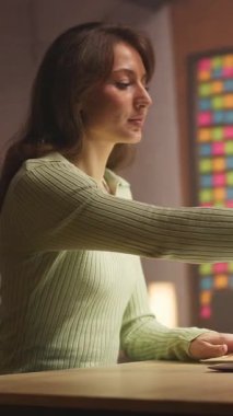 Nane rengi kazaklı güzel bir beyaz kadın dizüstü bilgisayarda oturuyor ve klavyeye yazarak içeride geziniyor. Evde çalışan sorumluluk sahibi bir iş kadınının görüntüsü. E-ticaret. Etrafta dolanıyorum.