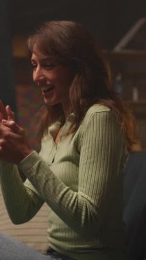 Oturma odasında dizüstü bilgisayar kullanan kendinden emin, mutlu, üretken, beyaz bir kadın. Geceleri oturma odasında çalışan güzel bir kızın görüntüsü. Hız kavramı. Kamera hareket ediyor