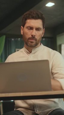 Masada oturan adamın portresi dizüstü bilgisayarı kullanır ve ofisteki not defterine not alır. Kamera hareket ediyor. 360 Derece