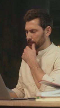 Kapalı dizüstü bilgisayarda oturan gülümseyen adam ofiste mutlu ve düşünceli. İş günü kameranın hareket etmesi sona erdi. 360 Derece