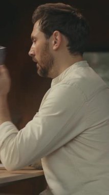 Not defterine yazan sakallı genç adam iş yerinde masa başında oturuyor. Düşünüyorum. Sosyal medyada telefon yazmayı kullan. Kamera hareket ediyor. 360 derece