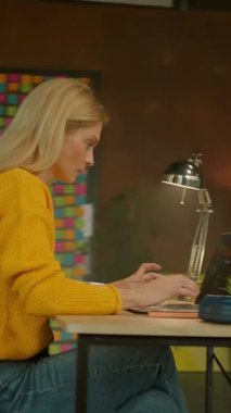 Ofisteki not defterine dizüstü bilgisayarla yazı yazan odaklanmış bir iş kadını. Yoğun bir iş günü. Kamera hareket ediyor. 360 derece