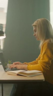 Dizüstü bilgisayarda yazan meşgul bir kadın ofiste telefon kullanıyor. İş günü. Düşünüyorum. Kamera hareket ediyor. 360 derece