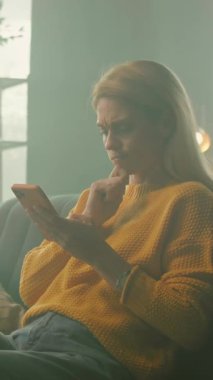 Tablet bilgisayar kullanarak koltukta oturan gülümseyen kadın kendini mutlu hissediyor. Odada güneş ışığı var. Dinlenme zamanı. Kamera hareket ediyor. 360 derece