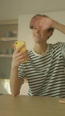 360 derece zaman ayarlı. Neşeli, genç, beyaz bir adam akıllı telefondan video görüşmesi yapıyor. Elinde cep telefonu olan ve konuşan bir adam. Erkek öğrenci sohbetten zevk alıyor. İz sürme