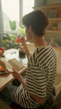 Beyaz adamın kahvaltı masasında otururken çekilen görüntülerini takip ediyorum. Genç adam tabağa portakal dilimleri koyup kitap okuyor. 360 derece mutfak. Sabah rutini konsepti