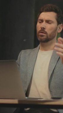 Kafkasyalı genç adamın yorucu bir işten sonra bilgisayarını kapatması üzücü. El ele tutuşan adam. Baş ağrısı konsepti. Kamera hareket ediyor. Parallaks etkisi. Optik yanılsama. Olumsuz duygular