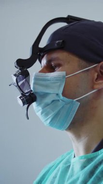 Tıbbi maskeli özel gözlü modern klinik dişçisinde dişleri tedavi eden diş aletleri bulunur. Hydience ve sağlıklı.