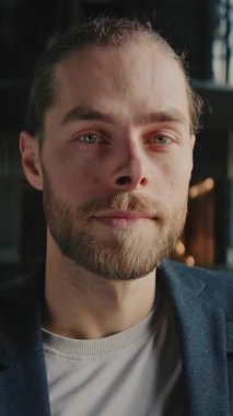 Kameraya gülümseyen yakışıklı adam portresi. Binanın içinde sakallı bir erkek.