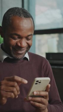 Mutlu, yakışıklı, gevşemiş, kahve içen ve öğle arasında akıllı telefondan mesaj atan Afrikalı bir adam. Keyifli bir iş adamı. Çatı katında ailesiyle sohbet ediyor. Gündüz