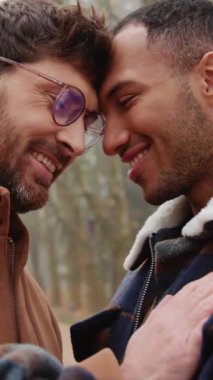 Paltolu mutlu homoseksüel çift parkta karşı karşıya duruyor.