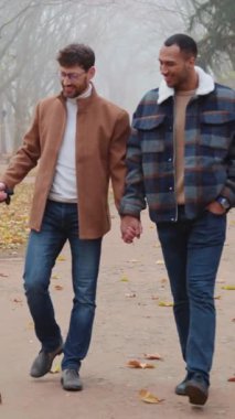 Eşcinsel bir çiftle güz mevsiminde parkta gezen neşeli bir çift.