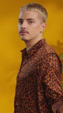 Gay gökkuşağı bayrağında bıyıklı, kendine güvenen bir adamın fotoğraf stüdyosu kameraya bakıyor.