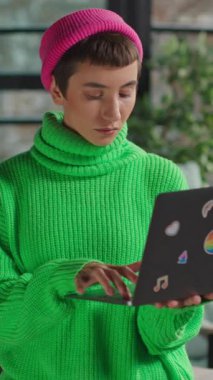 Dizüstü bilgisayarı olan kendine güveni tam bir biseksüel yaratıcı. İçerideki kameraya bakıyor.