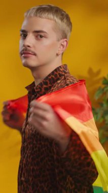 Gülümseyen adam omuzunda Lgbt bayrağı tutuyor şık gömlekler içinde kameraya bakıyor. Mutlu ol.