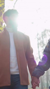 Birbirine aşık iki adamın el ele tutuşup doğada yürümesi.