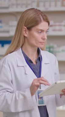 Profesyonel kadın danışman eczane dijital tabletle tıp öğreniyor, İnternet 'te ilaç detaylarını araştırıyor. Kimya. Tıp sektörü.