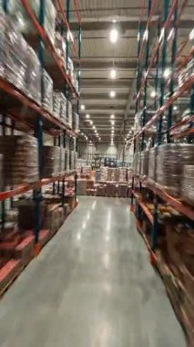 Lojistik merkezde hızlı FPV uçuşu. Teslimat malzemeleriyle dolu endüstriyel deponun hızlı hareket görüntüsü. Perakende deposu.