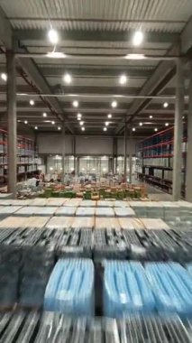 Modern perakende deposunun FPV insansız hava aracı hız görüntüsü. Teslimat kutularıyla birlikte lojistik merkezi ürün dağıtım deposu.