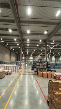 Lojistik depo FPV görüntüsü. Perakende sanayi deposunda hava aracı uçuşu. Teslimat malları ve personel işçileriyle dolu..