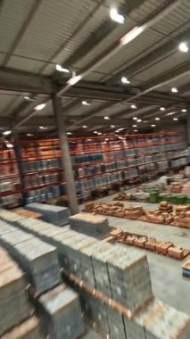 Depoda FPV hava uçuşu. Teslimat malları olan büyük bir sanayi deposu. Lojistik konsept. Hız dronu görünümü.