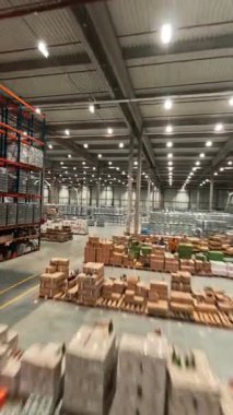 FPV uçuşu lojistik merkezine. Teslimat malları ile dolu modern büyük mağaza binası. Endüstriyel depo. Hava görünümü hız uçuşu.