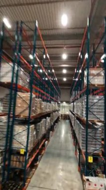 Çağdaş endüstriyel perakende deposunda hızlı FPV insansız hava aracı uçuşu. Teslimat malları ve ulaşımla dolu büyük bir lojistik park. Zaman ayarlı görünüm.