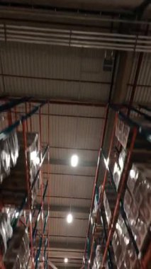 Modern lojistik merkezde FPV uçuşu. Karton kutularla rafların arasında uçmak. Perakende deposu. Ürün dağıtım konsepti.