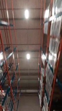 FPV insansız hava aracı görüntüsü modern endüstriyel perakende satış deposunda. Karton kutularla dolu raflar. Lojistik Merkezi Deposu.