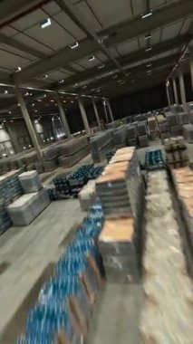 Modern büyük deponun içinde manevra kabiliyeti olan FPV uçuşu. Büyük lojistik merkezi ürün dağıtım deposuna bak. Mallı raflar.