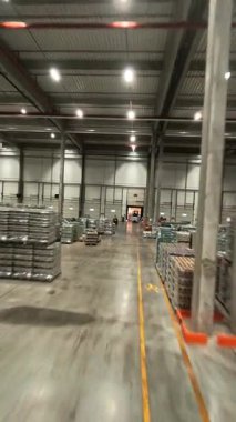Modern lojistik merkezin FPV uçuş görüntüsü. Çalışan işçilerle birlikte endüstriyel ürün dağıtım deposu. Perakende deposu.