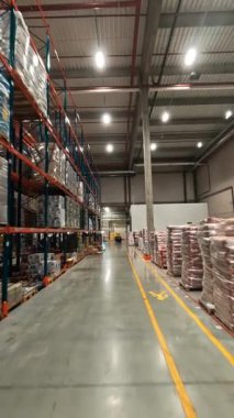 FPV İHA uçağını endüstriyel deponun içinde görüntüleyin. Lojistik parkı. Dağıtım malzemeleriyle dolu büyük bir depo..