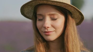 Saman şapkalı genç bir kadının rengarenk lavanta çiçekleriyle çevrelendiği huzurlu bir an.