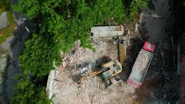 Çevredeki yeşillikler arasında makineler ve enkazlarla dolu yoğun bir inşaat alanının genel görüntüsü.