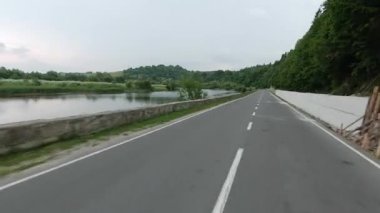 Berrak ve huzurlu bir yol manzarası, yemyeşil ve her iki tarafta yükselen ağaçlar, doğa severler için ideal.