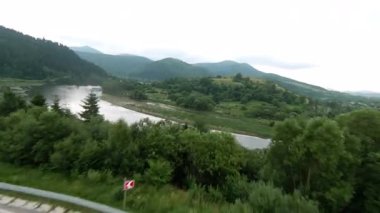 Şaşırtıcı derecede güzel, dolambaçlı bir yol canlı yeşil ormanlar ve görkemli yuvarlanan tepeler arasında yol alır.