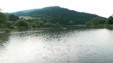 Huzurlu, sakin bir göl manzarası yemyeşil tepelerle çevrili, güzel yansıyan doğa zengin güzellik.