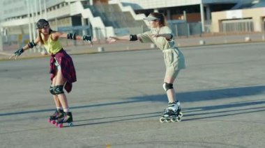 NEW YORK - 5 Ekim 2020: İki güzel kız dışarıda paten kayıyor eğlenceli sokak bacakları yapıyor arkadaşlar ağır çekimde paten kayıyorlar