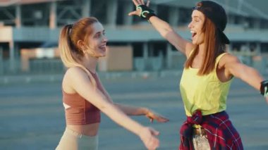 Çekici iki erkek portresi. Birbirlerine sarılmış kameraya bakın. Dışarıda paten kayıyorlar.