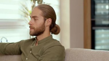 Evdeki rahat atmosferin keyfini çıkarırken at kuyruklu, kameraya gülümseyen yakışıklı beyaz adamın portresi. Sıradan insanların yaşam tarzı. Yakışıklı bir yüz. Gençlik kavramı.