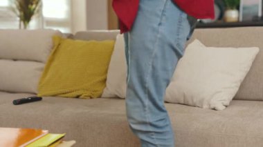 Şaşırmış genç Afro-Amerikalı adam telefon tebessümleri kullanın evdeki kanepede rahatlayın iş telefonu uygulaması otantik faturalar günbatımı yakın cep telefonu ağır çekim portresi yakışıklı