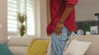 Kapatın genç Afrikalı Amerikalı adam telefon kullanıyor evdeki kanepede oturun. Sosyal medyada iletişim kurmak iş uygulamasını gevşetiyor. Yakışıklı adammış. - İnternet. Yavaş çekim