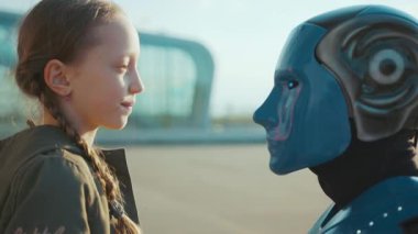 Mutlu çocuk kız, robot arkadaşını selamlıyor. Alnına dokunuyor. Gelecekteki makine zekası yapay insansı bilim robotikleri.