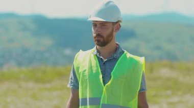 Gülümseyen genç işçi, güneş ışığı teknolojisindeki özel üniforma alanındaki kamera mühendislerine bak. Modern elektrik enerjisi portresi yavaş çekimde.