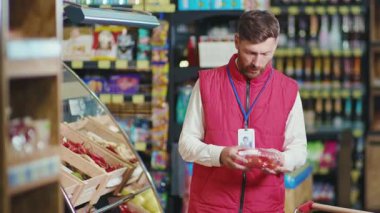 Çekici genç satıcı sebzeleri süpermarketin raflarına koyuyor sebzeler, sebzeler, taze ürünler, perakendecilik, yavaş çekim.